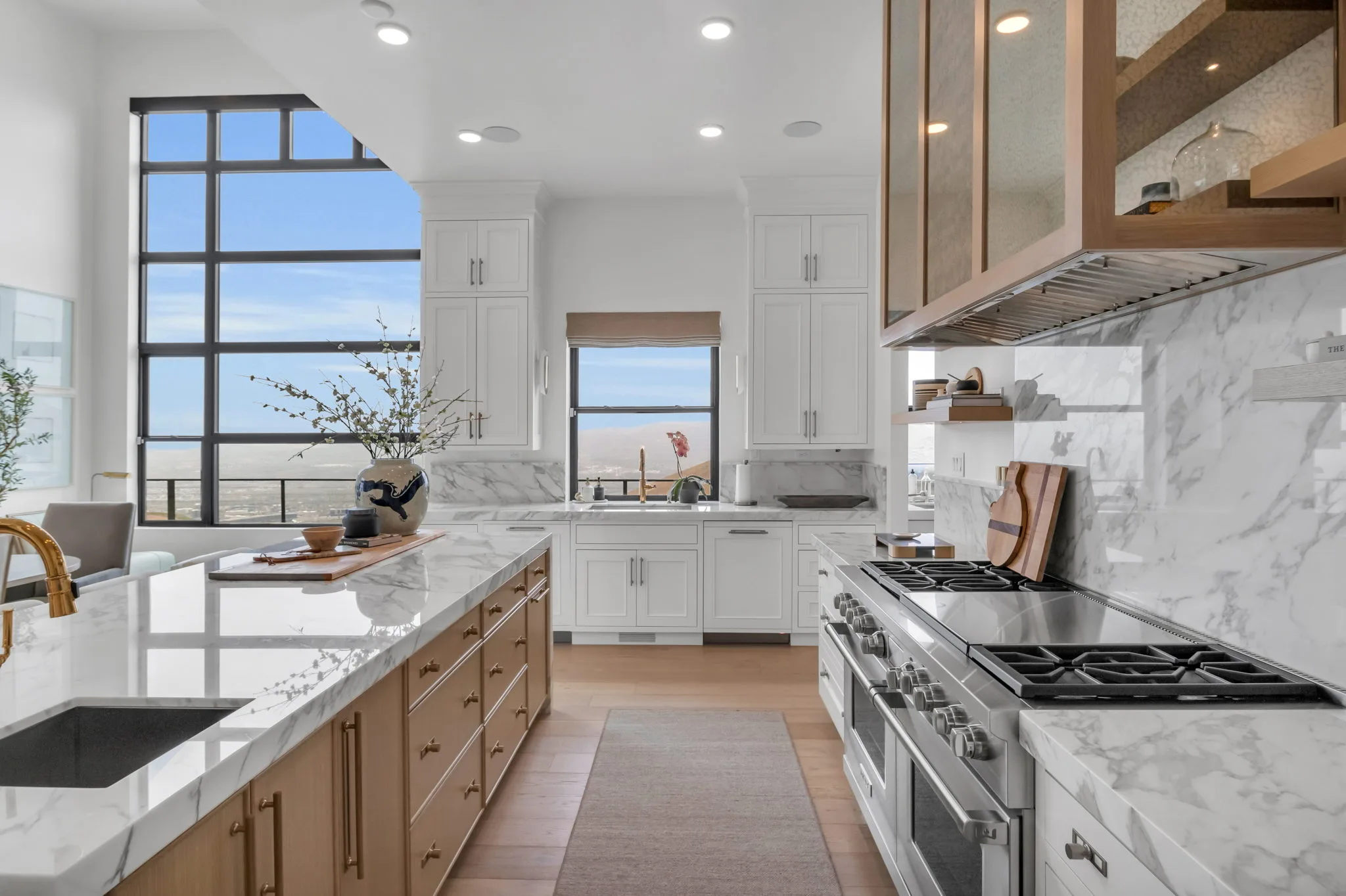 Custom chef's kitchen with marble countertops, professional range, and mountain-view windows in a Bird-built Utah home