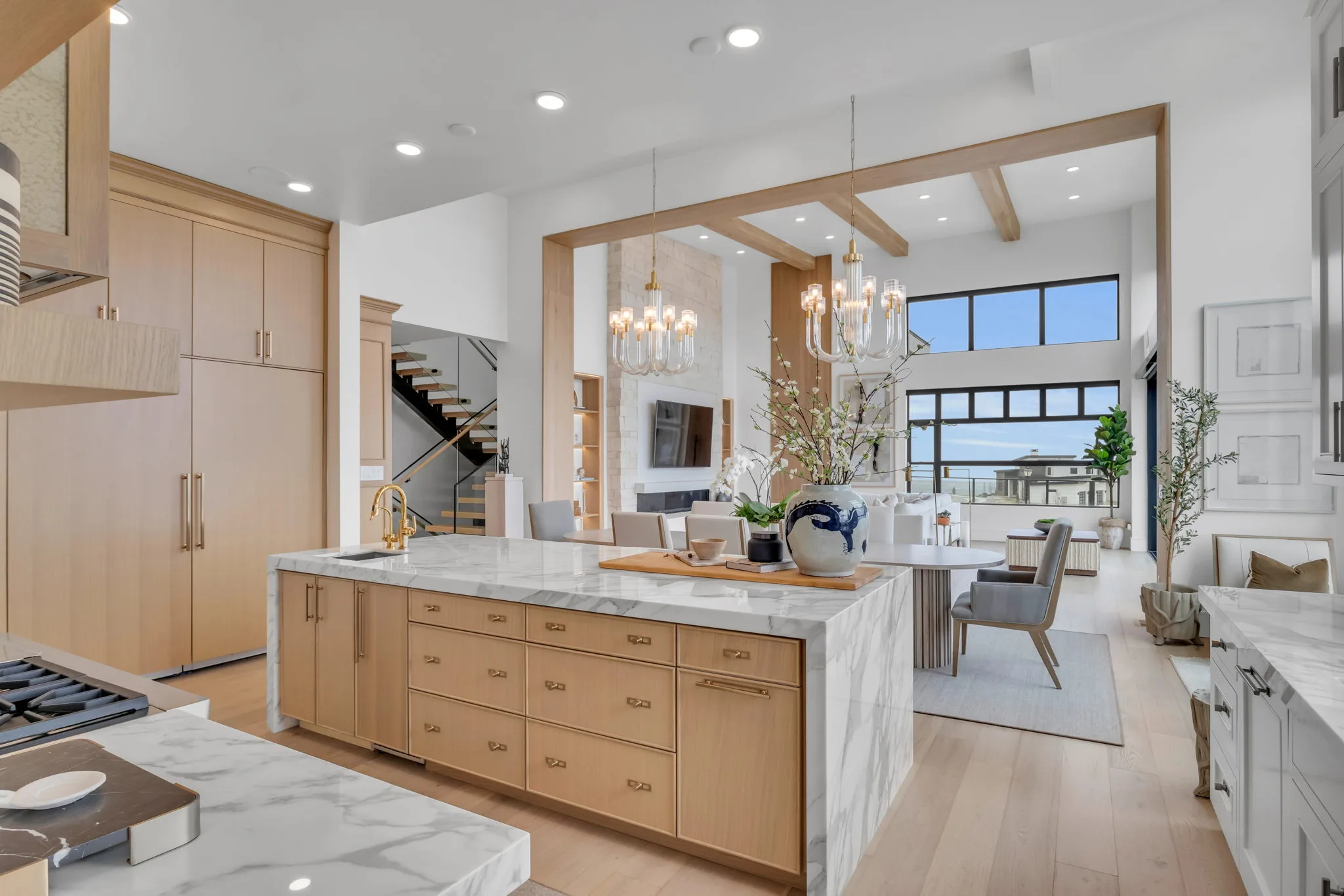 Open kitchen and living area with exposed wood beams and oversized island in a Bird custom home in Utah